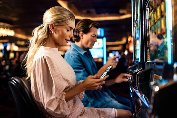 A man celebrating a winning moment on his laptop while gaming symbols float around him, capturing the excitement of KU9 games.
