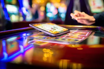 A person using their device against a moody casino-themed background, illustrating the smooth re-entry process at KU9.
